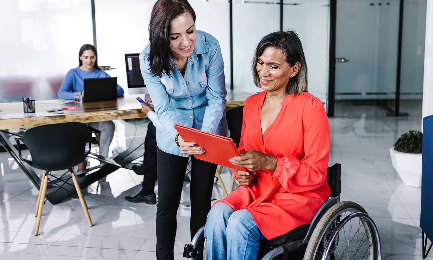 A person in a wheelchair looking at a tablet